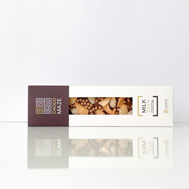 Chocomaze Karamelizált Alma díszített táblás tejcsokoládé díszdobozban, 31,6% kakaótartalommal, fahéjas almaszeletekkel, mandulával és karamellizált ostyagolyókkal.