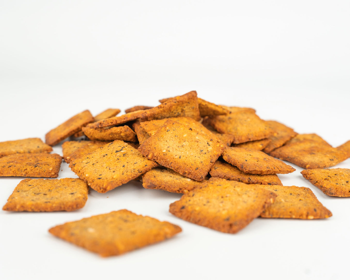 Ropogós Vilgain BIO Quinoa krékerek halmaza fehér háttér előtt, paradicsomos bazsalikomos ízben.
