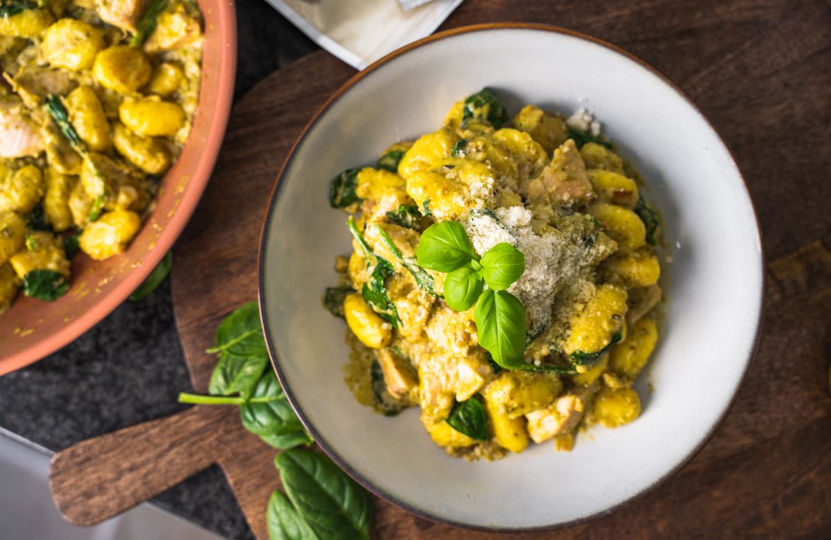 Gnocchi tányéron, Vilgain Vegán Pesto Genovese szósszal, friss bazsalikommal, spenóttal és parmezán sajttal tálalva.