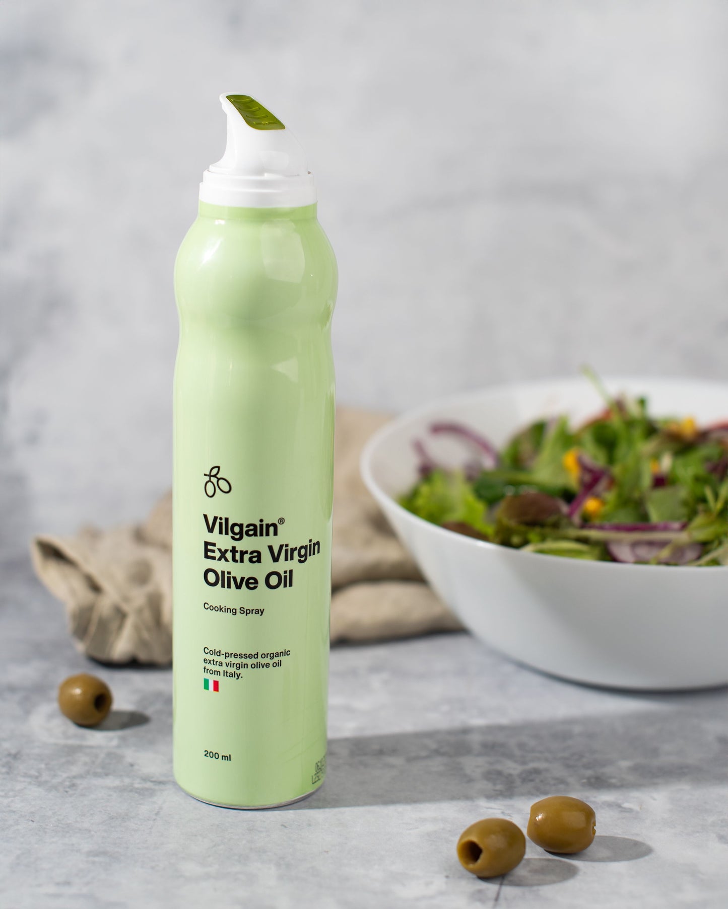 Vilgain BIO Olívaolaj spray közelről, friss zöldségek mellett.